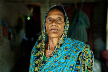 Sundarbans, Hindistan - 23 Ekim 2023: Hindistan 'ın kırsal kesimindeki küçük bir köyde evinin içinde geleneksel bir sari giyen yaşlı bir Hintli dulun portresi.