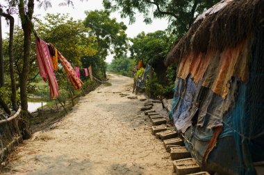 Sundarbans, Hindistan - 20 Ekim 2023: Hindistan 'ın kırsal kesimindeki bir köyde asfaltsız toprak bir yol. Hindistan 'da altyapı ve kalkınma kavramı