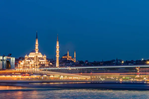 İstanbul şehir manzarası - gün batımında feribot ile caminin panoramik manzarası. İstanbul 'un geceleyin uzun süreli manzarası