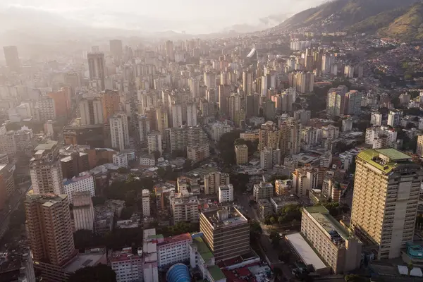 Gün batımında Caracas 'ın gökdelen ve gecekondu manzarası görülebilir. Gün batımında Venezuela başkentinin insansız hava aracı çekimi. Gelişmekte olan bir ülkede kalkınma kavramı