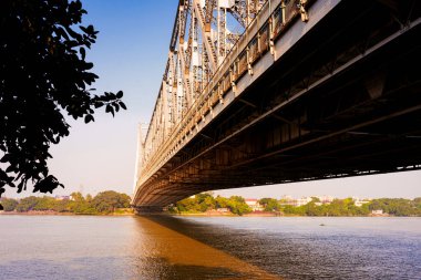 Hooghly nehri ve Calcutta 'daki ikonik Howrah köprüsü sabah gün doğumunda görülür. Kolkata 'da Hint mimarisi örneği