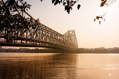 Hooghly nehri ve Calcutta 'daki ikonik Howrah köprüsü sabah gün doğumunda görülür. Kolkata 'da Hint mimarisi örneği