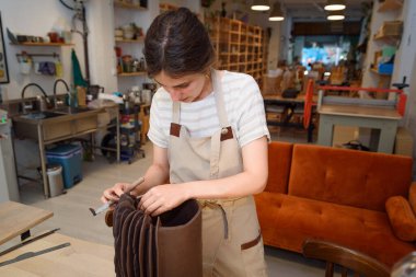 Çömlek atölyesinde duran kadın çömlek yapmak için çiğ seramik vazo ve kil üzerinde çalışıyor. Doğal ışık kazıma, düzleştirme, şekillendirme ve yontma ile çömlek atölyesi. Kil tenceresi yapmak