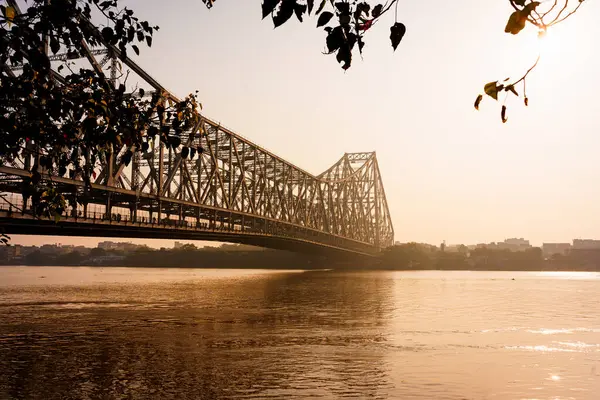 Hooghly nehri ve Calcutta 'daki ikonik Howrah köprüsü sabah gün doğumunda görülür. Kolkata 'da Hint mimarisi örneği