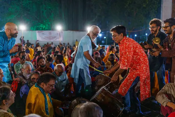 Baroda, Hindistan - 17 Ekim 2023: Geleneksel sari ve kurta elbiseli Hintli insanlar Hindu Navratri festivali sırasında Tanrıça Durga 'yı onurlandırmak için Garba müziği yapıyorlar..
