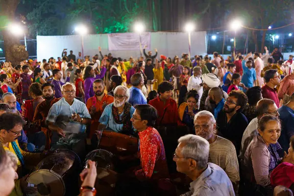 stock image Baroda, India - 17th October 2023: Indian people in traditional sari and kurta dresses dance the Garba music during the hindu Navratri festival to honor the goddess Durga.