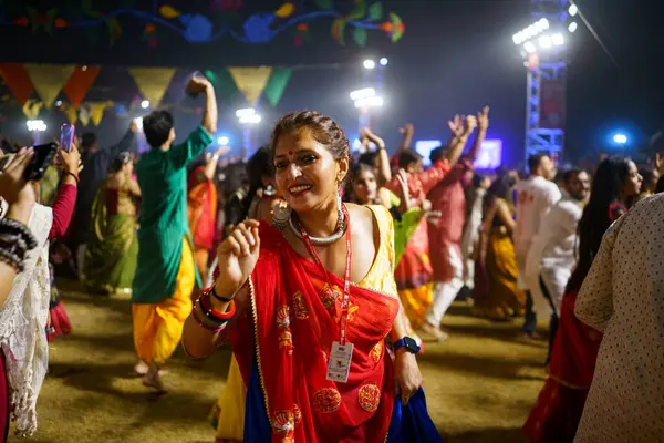 Baroda, Hindistan - 17 Ekim 2023: Geleneksel sari ve kurta elbiseli Hintli insanlar Hindu Navratri festivali sırasında Tanrıça Durga 'yı onurlandırmak için Garba müziği yapıyorlar..