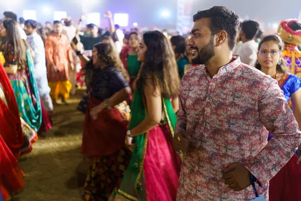 Baroda, Hindistan - 17 Ekim 2023: Geleneksel sari ve kurta elbiseli Hintli insanlar Hindu Navratri festivali sırasında Tanrıça Durga 'yı onurlandırmak için Garba müziği yapıyorlar..