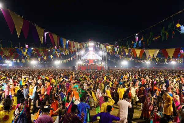 Stock image Baroda, India - 17th October 2023: Indian people in traditional sari and kurta dresses dance the Garba music during the hindu Navratri festival to honor the goddess Durga.