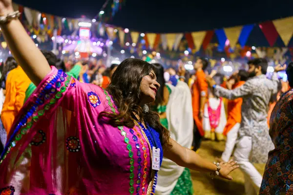 stock image Baroda, India - 17th October 2023: Indian people in traditional sari and kurta dresses dance the Garba music during the hindu Navratri festival to honor the goddess Durga.