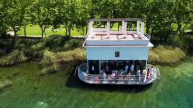 İspanya 'nın Katalonya kentindeki güneşli bir günde Banyoles balıkçılarının evinin hava manzarası. Yazın Banyoles Gölü 'nün insansız hava aracı videosu