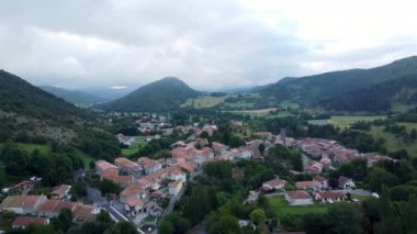 Gökyüzü bulutlu Ariege bölgesindeki Belcaire adlı küçük bir Fransız köyünün hava manzarası. Klasik küçük Fransız kasabası drone sinematik çekimi.