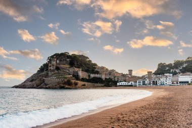 Tossa de Mar plajı gün batımında sıcacık bir ışık ve şatoyla görüldü. İspanya 'nın Kosta Brava kıyılarında ünlü bir turizm beldesi.