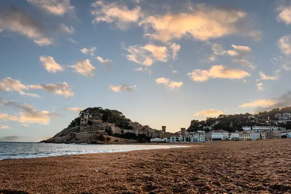 Tossa de Mar plajı gün batımında sıcacık bir ışık ve şatoyla görüldü. İspanya 'nın Kosta Brava kıyılarında ünlü bir turizm beldesi.