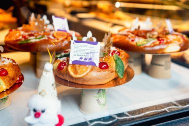 Barselona, İspanya - 20 Aralık 2024: Geleneksel Roscon de Reyes kekleri şehir merkezindeki bir pastanede görülür. Üç Kralın kutlamaları için Katalan ve İspanyol pastanesi ve geleneksel tatlılar