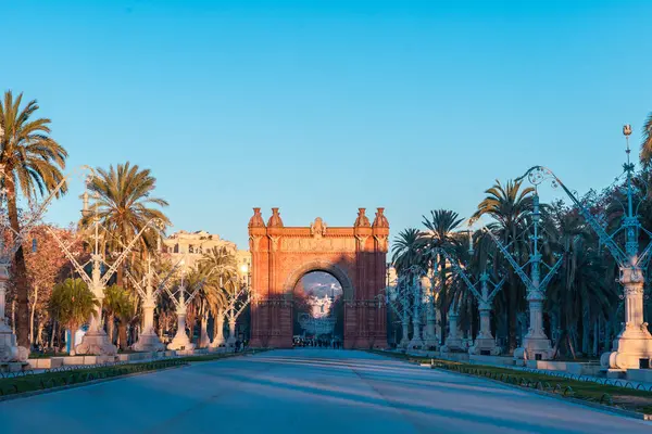 Barcelona 'daki tarihi ARC de Triomf' un şafak manzarası. Açık mavi gökyüzü ve altın gibi sıcak bir ışık. Katalonya 'daki Paseo de Lluis Şirketleri' nde hiç kimse yok.