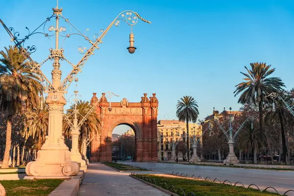 Barcelona 'daki tarihi ARC de Triomf' un şafak manzarası. Açık mavi gökyüzü ve altın gibi sıcak bir ışık. Katalonya 'daki Paseo de Llus Şirketleri' nde hiç kimse yok.