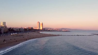 Gün batımında Barceloneta sahilinin insansız hava aracı görüntüsü. Akdeniz manzaralı karanlık bir şehir manzarası. Günbatımı silüeti. Marina Caddesi ve Olimpik Limanı