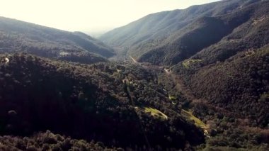 Güneşli bir günde açık mavi gökyüzü ile Montseny Vadisi 'nin dağlı ve gür yeşil ormanlı hava aracı manzarası