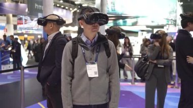 Barselona, İspanya - 28 Şubat 2025: Sanal gerçeklik kulaklığı kullanan insanlar bir ticaret fuarında görülüyor. VR dijital simülasyon kavramı, gelişmiş teknoloji sergileniyor