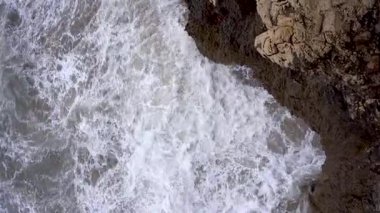 Ağır çekim dalgalarının kayalardan oluşan bir uçuruma çarpması. Tehlikeli Akdeniz 'e çok yakın. Doğanın gücü kavramı