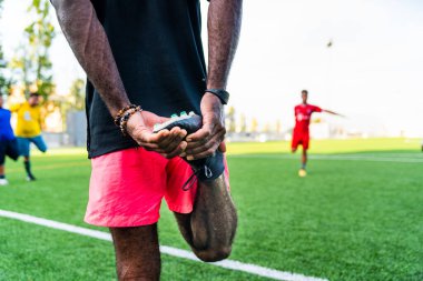 Çok ırklı ve çeşitli eğitimli Afrikalı genç bir adamın portresi. Futbol sahasında spor ve egzersiz yapan genç bir sporcu