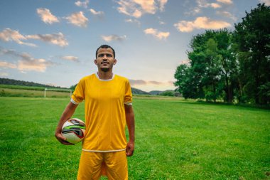 Açık hava futbol sahasındaki genç Arap futbolcunun portresi. Futbol sahasında spor ve egzersiz yapan umut dolu genç bir göçmen sporcu.