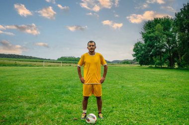 Açık hava futbol sahasındaki genç Arap futbolcunun portresi. Futbol sahasında spor ve egzersiz yapan umut dolu genç bir göçmen sporcu.