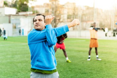 Orta Doğu 'lu genç bir adam futbol sahasında antrenman yapıyor. Futbol sahasında spor ve egzersiz yapan genç bir sporcu