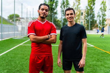 Açık hava futbol sahasında genç bir Arap futbolcunun portresi. Futbol sahasında spor ve egzersiz yapan umut dolu genç bir göçmen sporcu.