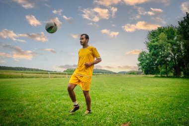 Açık hava futbol sahasındaki genç Arap futbolcunun portresi. Futbol sahasında spor ve egzersiz yapan umut dolu genç bir göçmen sporcu.