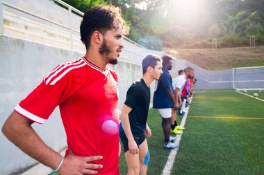 Açık hava futbol sahasındaki genç Arap futbolcunun portresi. Futbol sahasında spor ve egzersiz yapan umut dolu genç bir göçmen sporcu.