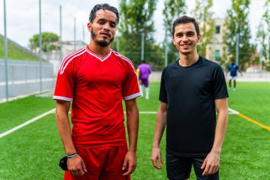 Açık hava futbol sahasında genç bir Arap futbolcunun portresi. Futbol sahasında spor ve egzersiz yapan umut dolu genç bir göçmen sporcu.