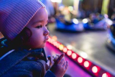 Gece vakti, Luna Park 'ta neon ışıklı portresi olan küçük bir kız bebek.