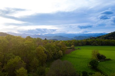 İspanya 'nın Katalonya bölgesindeki Garrotxa bölgesinin gün batımında bulutlu gökyüzü ile muhteşem hava manzarası. Yakınlardaki doğal manzara manzarası Olot