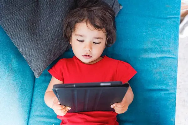 Yavru bebek tek başına tablet, ekran saati ve çocuklarda ekran bağımlılığı izliyor. Çocuklar, teknoloji ve ekran zamanı kavramı