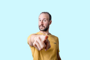 Genç adam kamerayı ciddi bir özgüven ifadesiyle işaret ediyor.