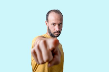 Genç adam kamerayı ciddi bir özgüven ifadesiyle işaret ediyor.