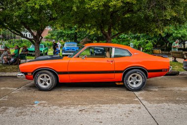 Des Moines, IA - 01 Temmuz 2022: 1974 Ford Maverick Grabber Coupe 'nin yerel bir araba fuarındaki yüksek perspektifli yan görüntüsü.