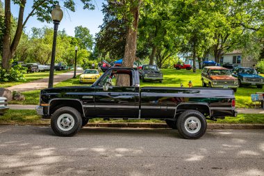 Des Moines, IA - 2 Temmuz 2022: 1984 GMC Sierra Classic 'in yerel bir otomobil fuarındaki yüksek perspektifli yan görüntüsü.