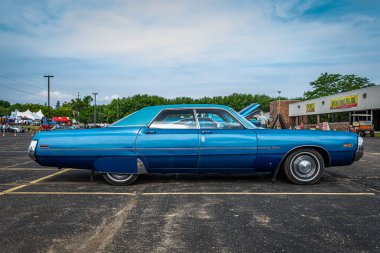 Iola, WI - Temmuz 07, 2022: Yerel bir araba fuarında 1971 Chrysler Newport Royal 4 Kapısı 'nın düşük perspektifli yan görüntüsü.