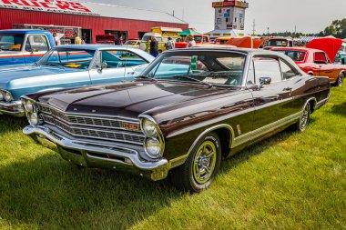 Iola, WI - July 07, 2022: High perspective front corner view of a 1967 Ford Galaxie XL Fastback at a local car show. clipart