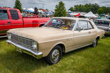 Iola, WI - Temmuz 07, 2022: 1966 Ford Falcon Futura Spor Coupe 'nin yüksek perspektifli ön köşe görüntüsü yerel bir araba fuarında.