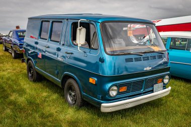 Iola, WI - 07 Temmuz 2022: 1969 Chevrolet Chevy 90 Van 'ın yüksek perspektifli ön köşesi yerel bir araba fuarında.