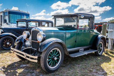 Fort Meade, FL - February 24, 2022: High perspective front corner view of a 1927 Hupmobile Series A Sport Coupe at a local car show. clipart