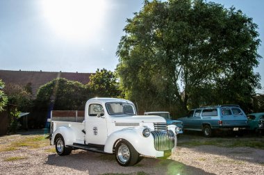 Beyaz araba Riga şehrinde bir caddenin kenarına park edilmiş..