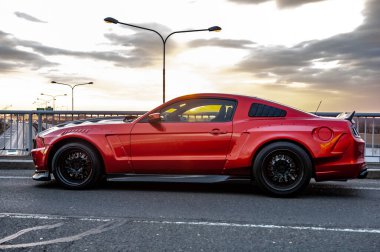 kırmızı Mustang araba sokağa park edilmiş.