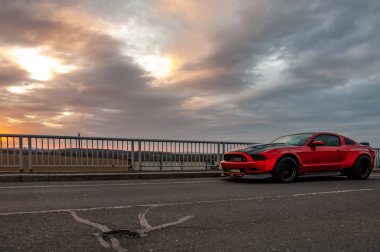 Kırmızı araba yolda.