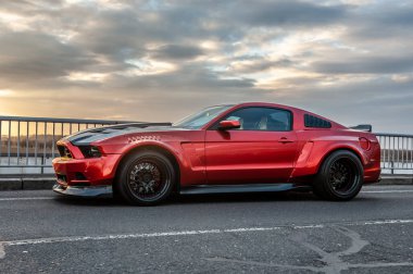 Kırmızı araba yolda.