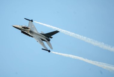 Askeri jet uçağı mavi gökyüzünde uçuyor.